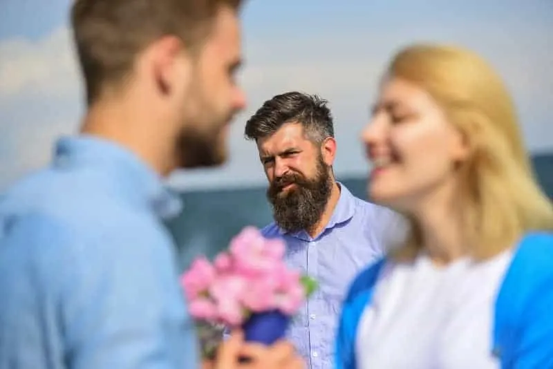 jealous man looking at couple