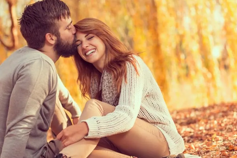 man kisses woman forehead