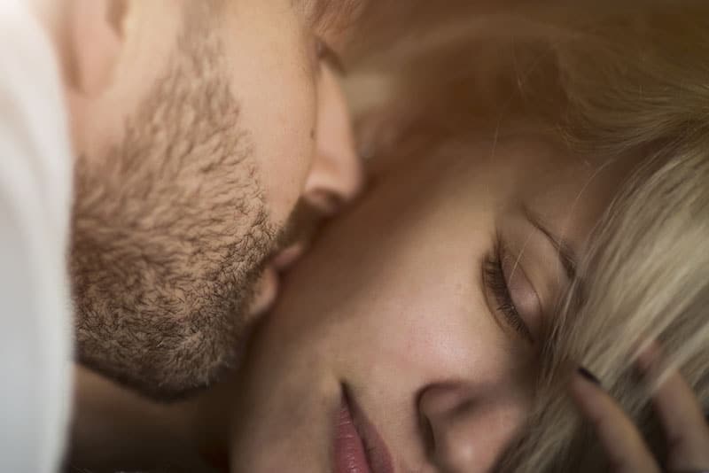 man kissing blond woman