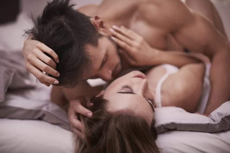 romantic couple kissing on bed