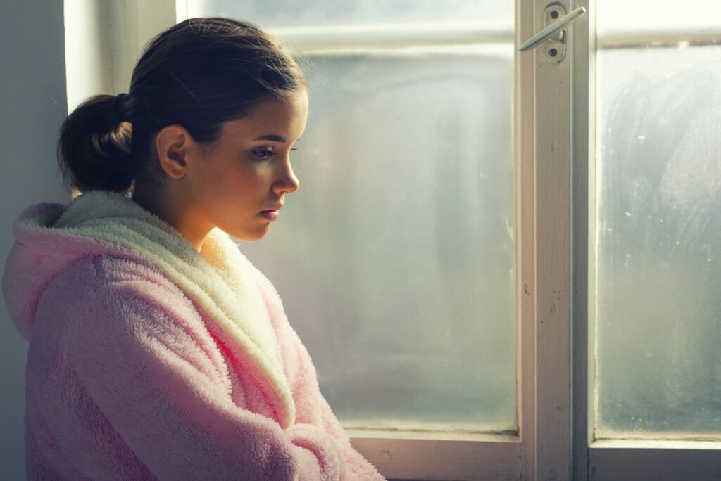 sad girl by the window
