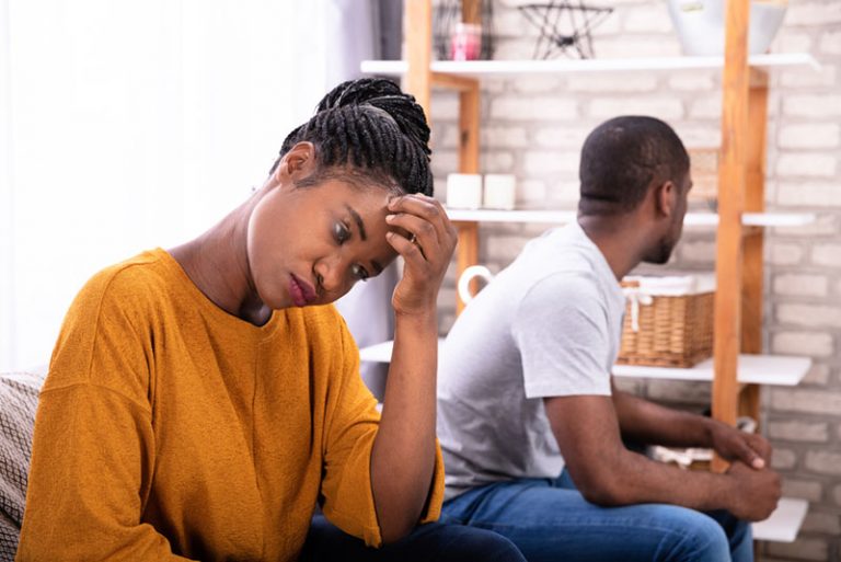 Upset Young African Couple Sitting On Sofa Ignoring Each Other
