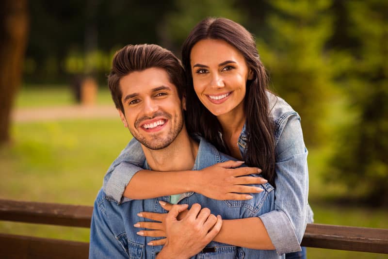 Close-up portrait of his he her she nice attractive lovely peaceful cheerful tender best partners wearing denim spending romance romantic honey moon embracing in green wood forest