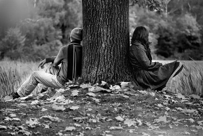 Uomo e donna seduti nel parco dopo una lite