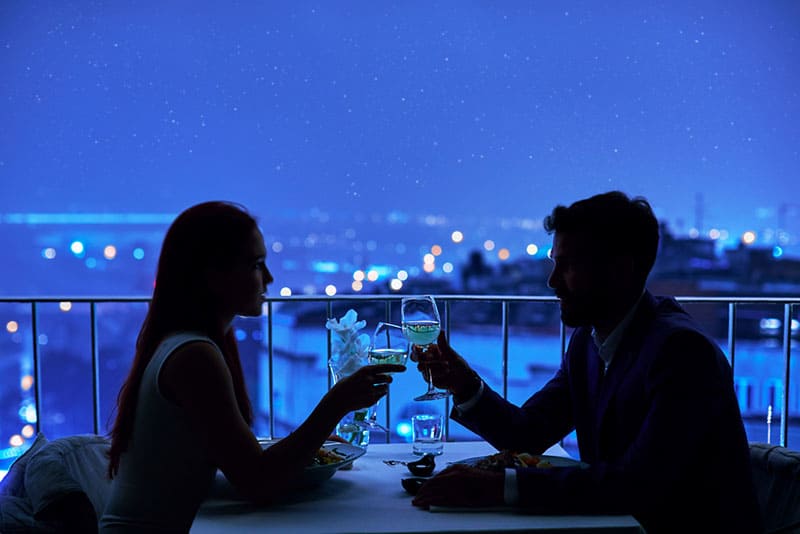 Young couple at restaurant having dinner. Silhouette