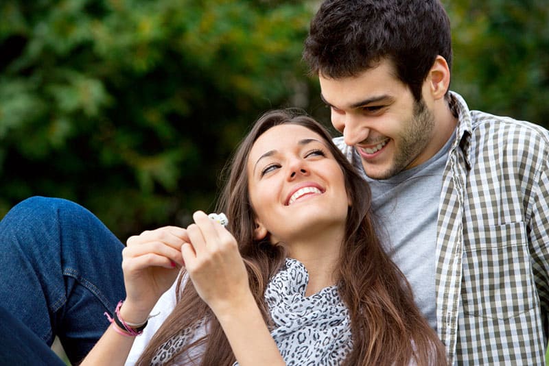 Retrato de cerca de atractiva pareja joven enamorada al aire libre.