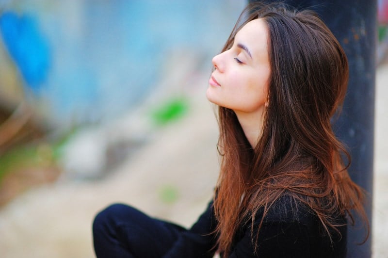 thankful woman with closed eyes outside