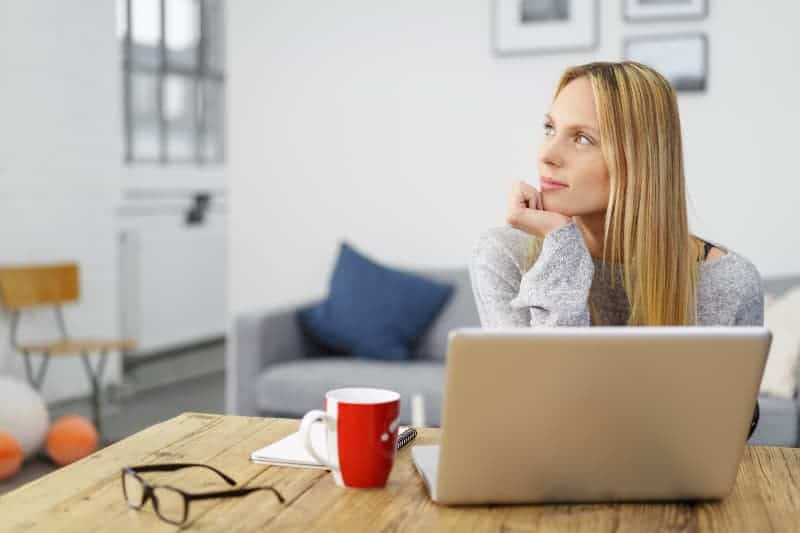 thoughtful woman sitting on table