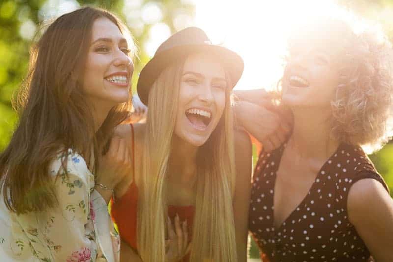 three smiling female friends