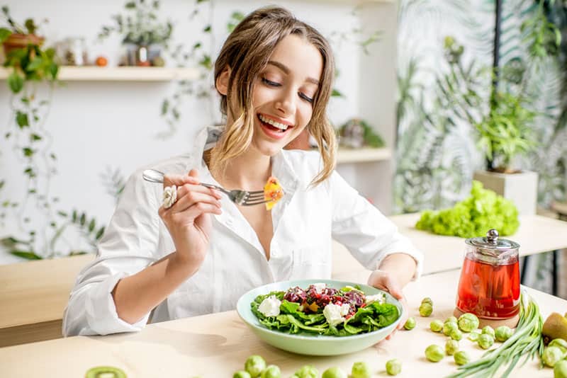 woman eating salad at home