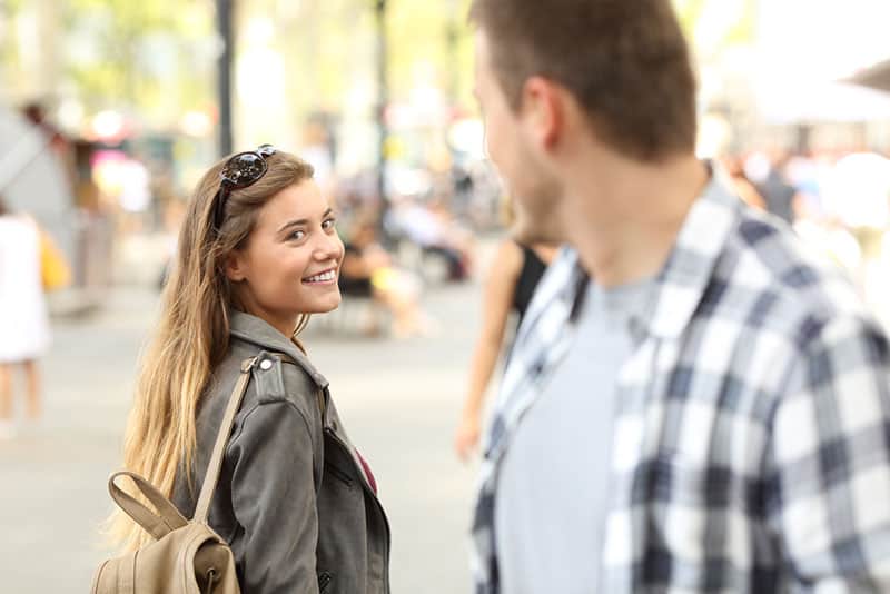 mujer flirteando con hombre en la calle