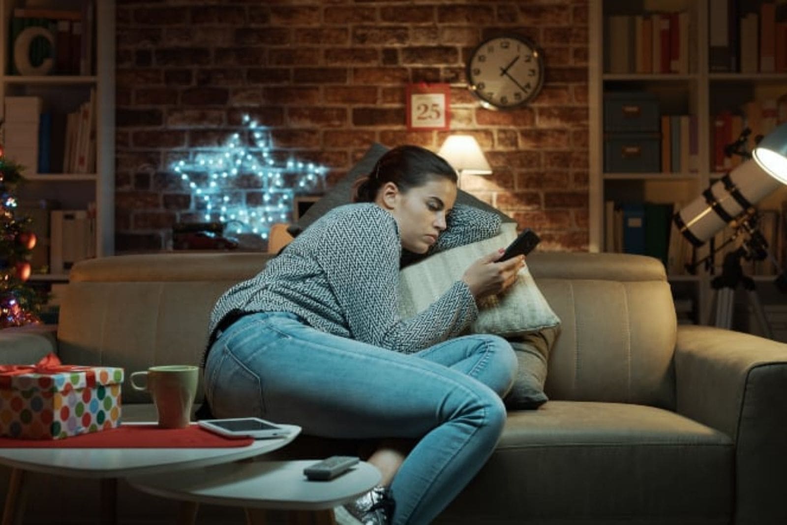mujer mirando su smartphone y sintiéndose sola en casa