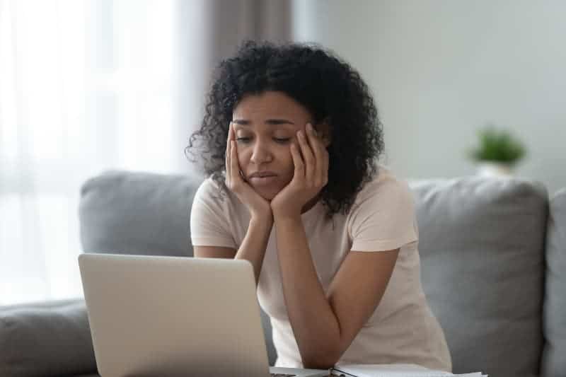 worried woman looking at laptop