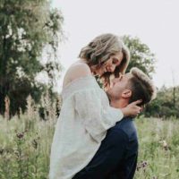adorable pareja abrazándose en un campo de hierba
