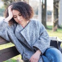 mujer triste en el banco de un parque