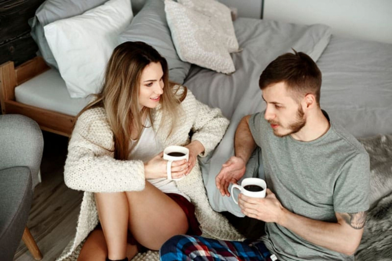 a man and a woman sit and drink coffee