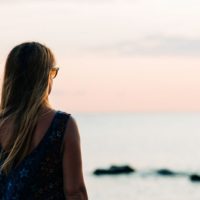 mulher de pé em frente ao mar