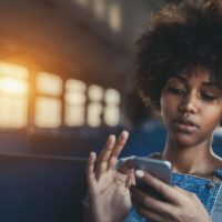 black gorgeous woman on the bus on her phone