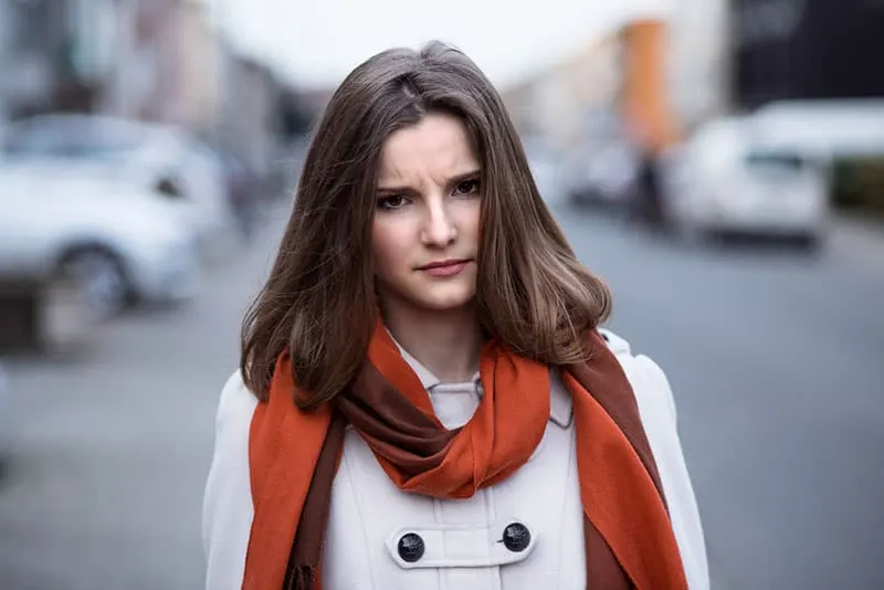 angry and annoyed woman with orange scarf in the street