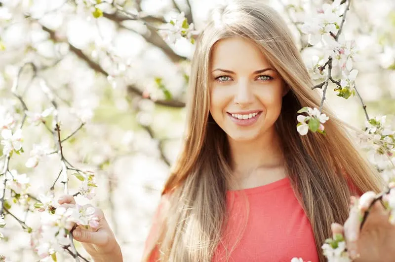 beautiful woman posing next to the blooming tree