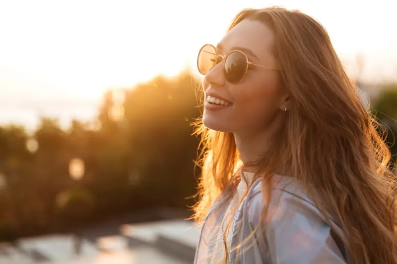 mulher alegre com óculos de sol ao ar livre