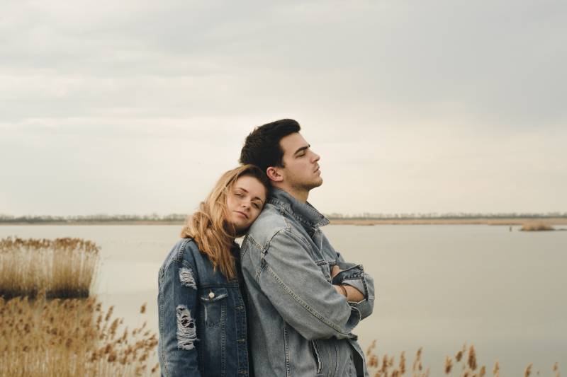 pareja pensativa frente a un lago