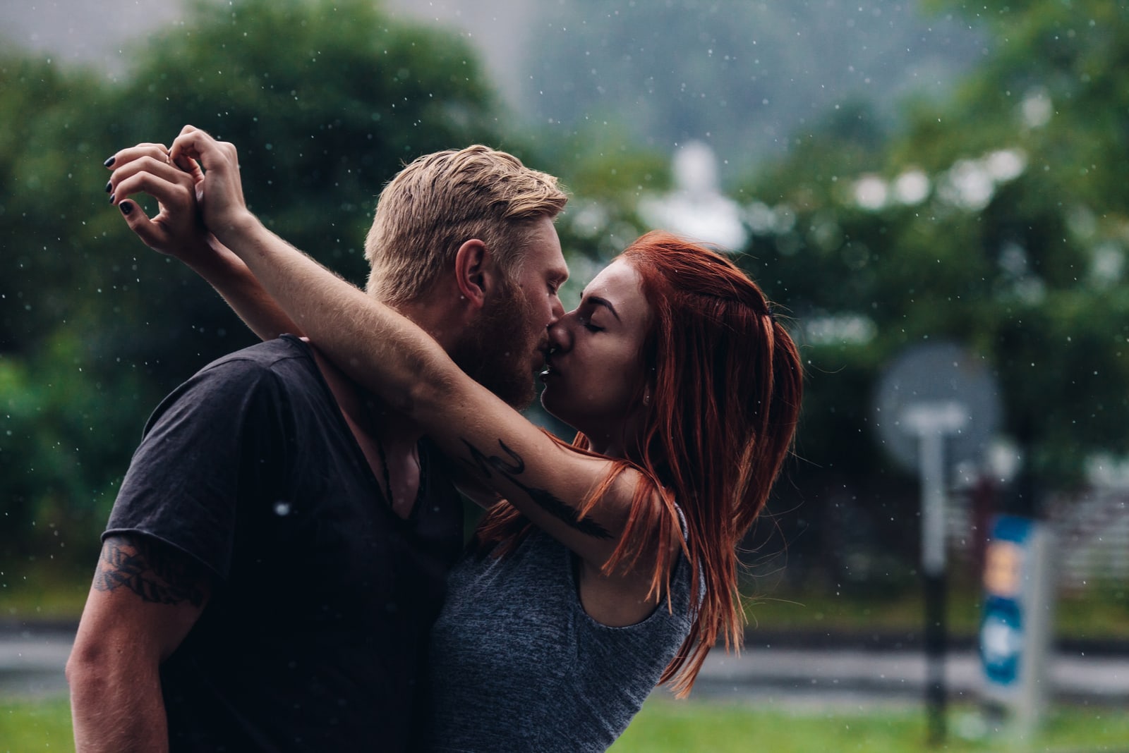 coppia che si bacia all'aperto sotto la pioggia