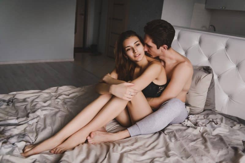 couple sitting bed hugging