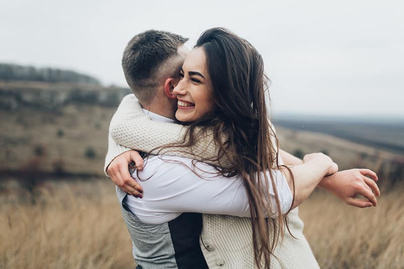 happy couple hugging outside