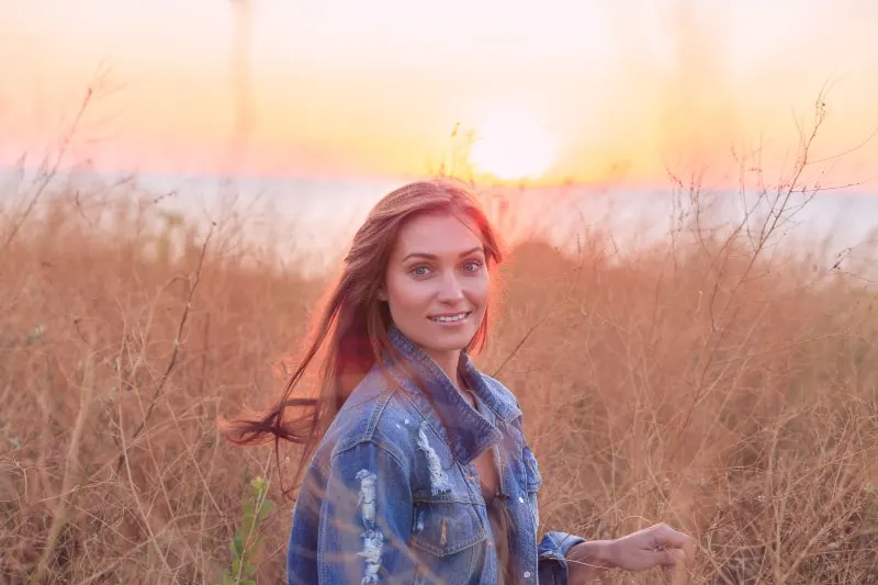 happy woman in field on sunset
