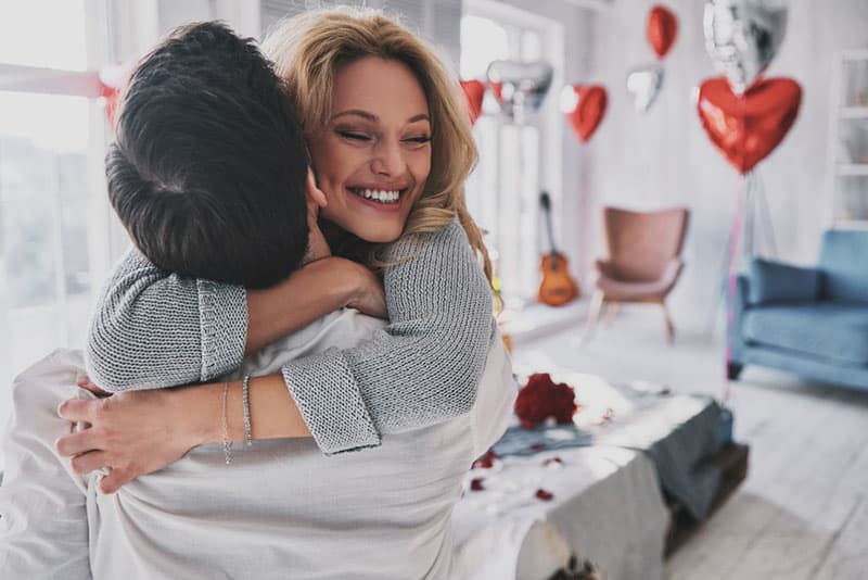 happy young couple hugging in their apartment