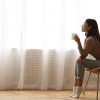 girl sitting on chair near window