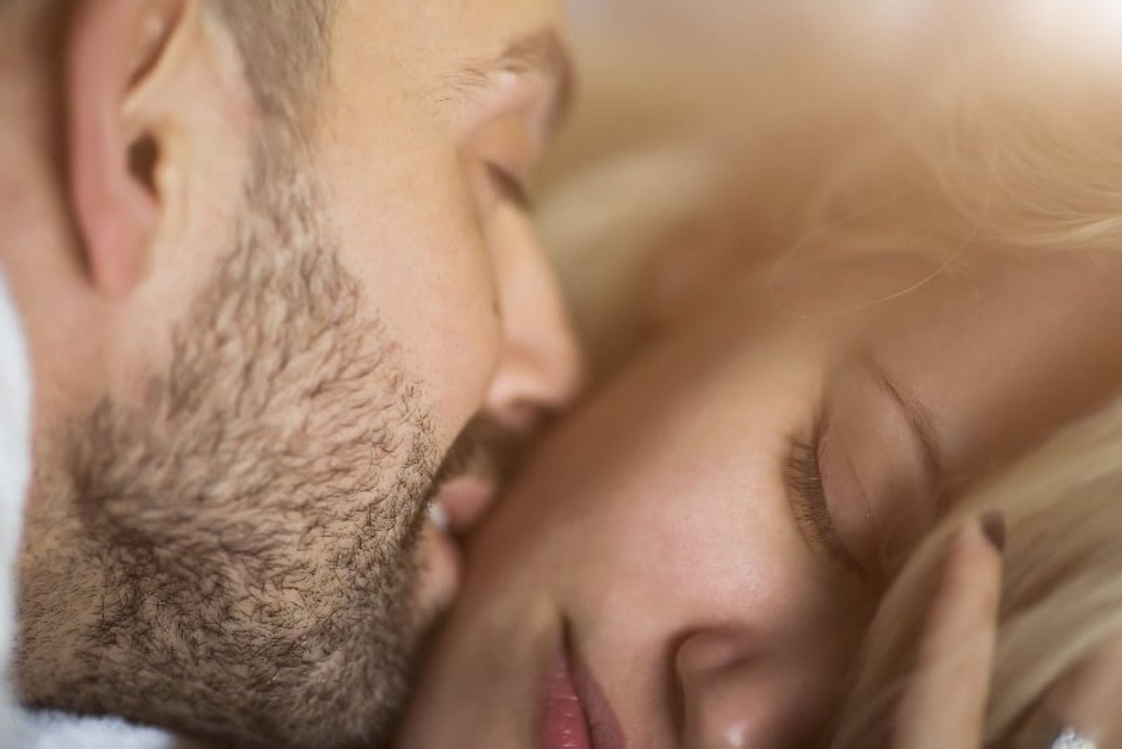 man kissing his sleepy girlfriend