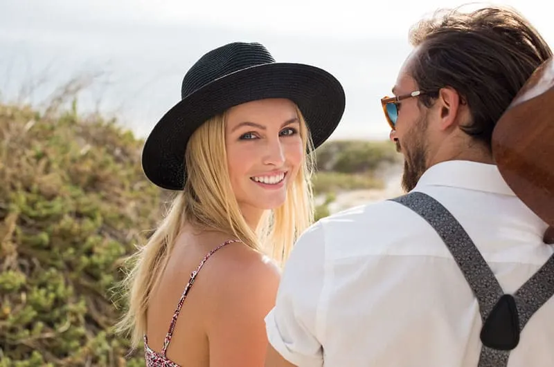 man looking at beautiful woman with hat