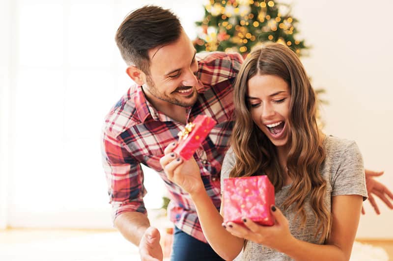 hombre sorprendiendo a mujer con el regalo