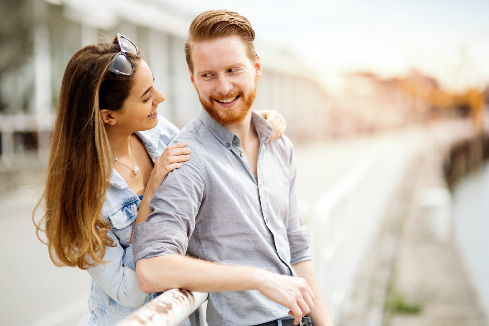 outside the brunette hugs a bearded smiling man