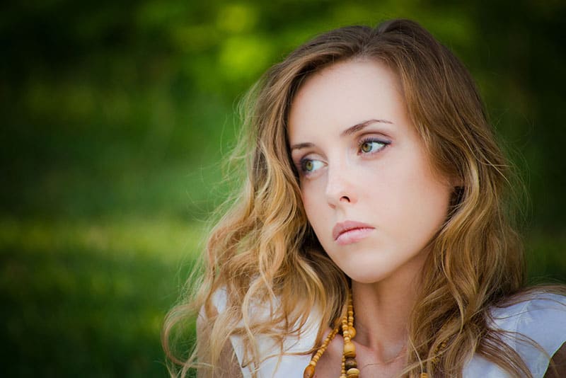 giovane donna bionda triste nel parco