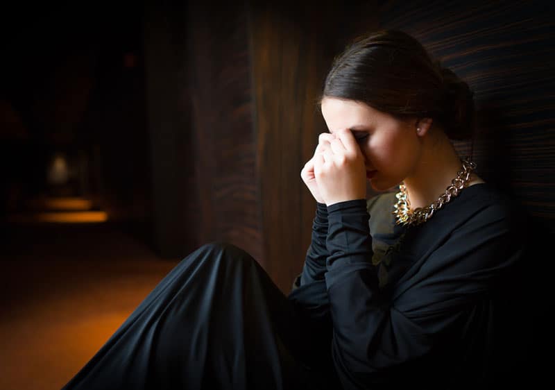 mujer triste llorando en un callejon