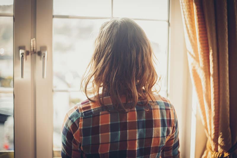 mujer triste mirando por la ventana