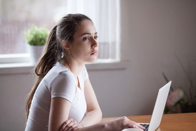 mujer seria y atenta sentada junto a la mesa