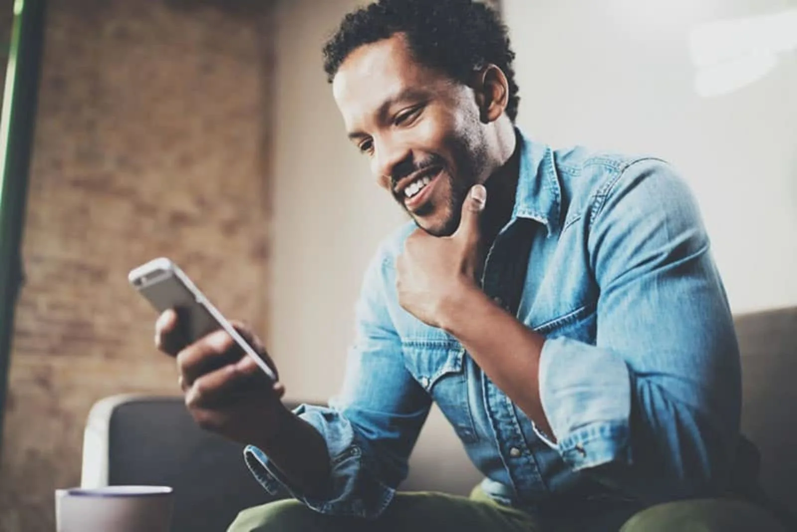 the man holds a phone and sits down
