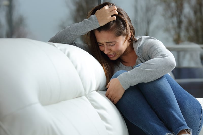 woman crying on couch