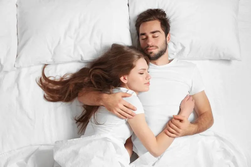 young couple in bed hugging