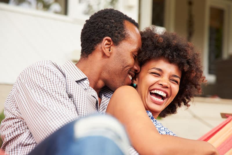 young couple laughing on couch