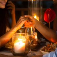 couple holding hand together during romantic dinner