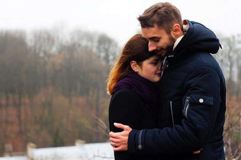 lovely couple hugging in nature beside water
