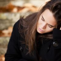 sad woman sitting outdoor on fresh air