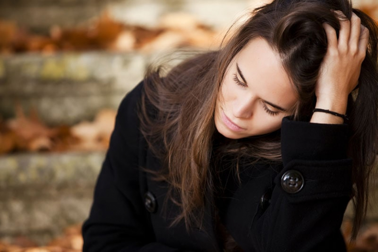 sad woman sitting outdoor on fresh air