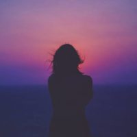 silhouette di donna che si affaccia sul tramonto