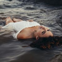 mujer triste flotando en el agua
